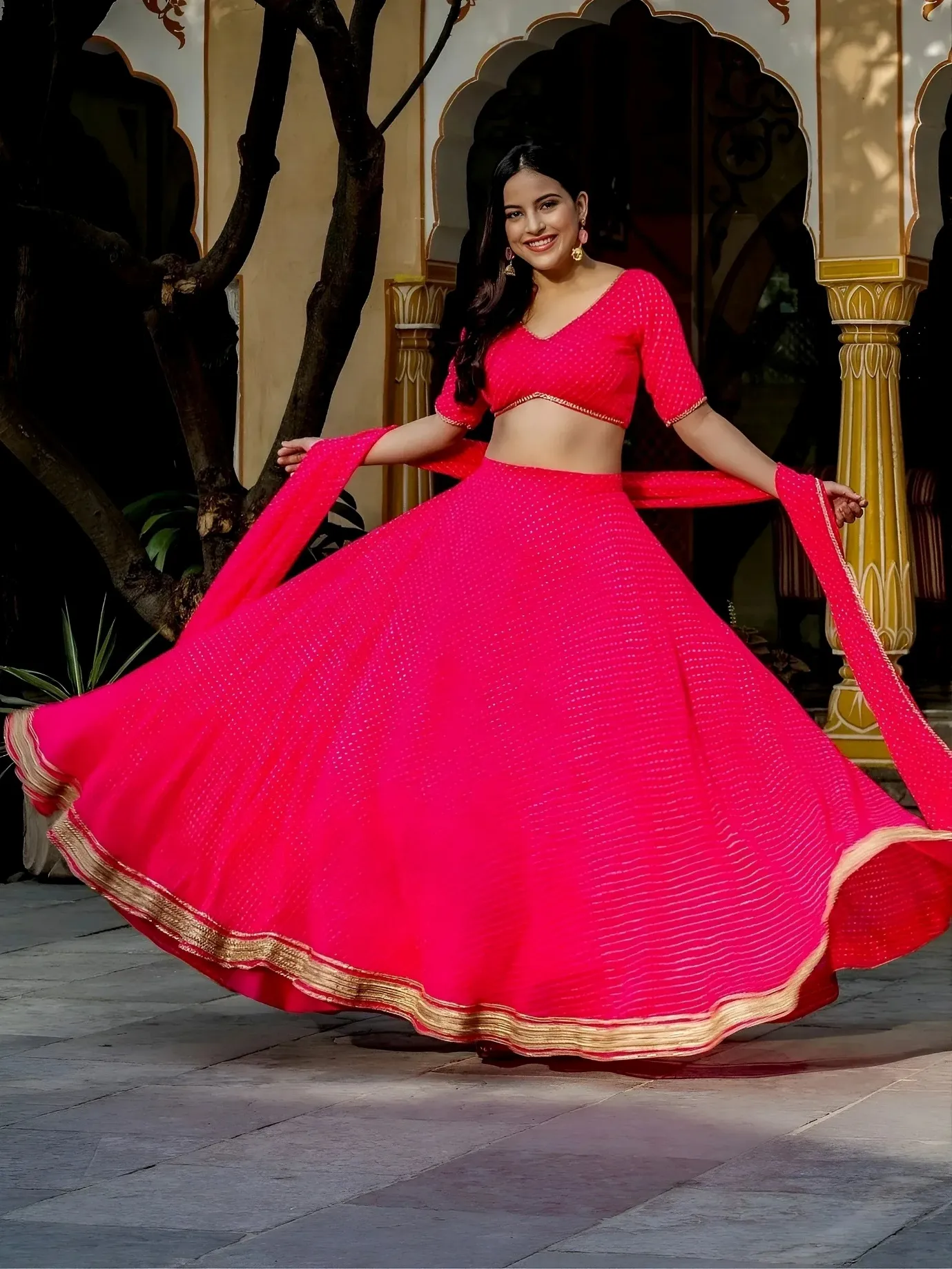 Vibrant pink lehenga choli with gold trim, perfect for Indian ethnic wear and festive occasions.