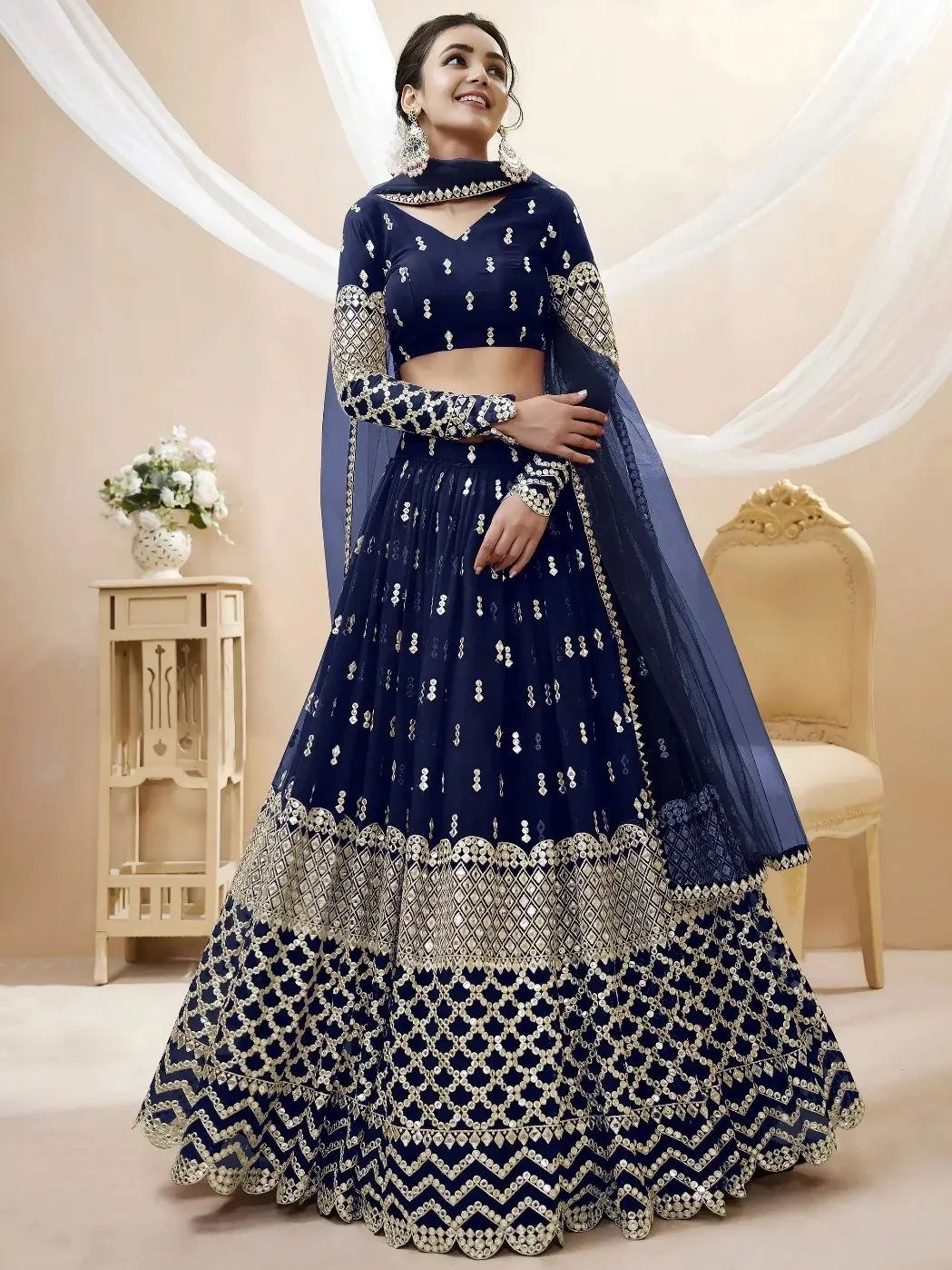Navy blue designer lehenga choli with gold mirror work and net dupatta, perfect for Indian weddings and festive occasions.