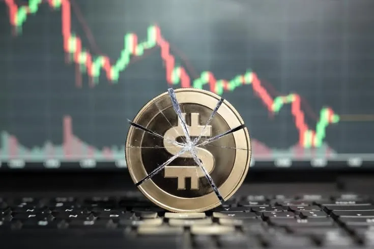 This may contain: a broken bitcoin sitting on top of a laptop computer with a stock chart in the background