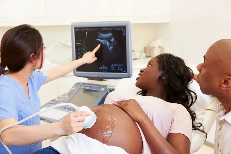 This may contain: a pregnant woman is hooked up to an x - ray machine while two doctors look on